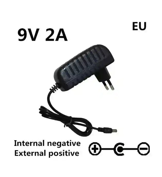 Pedal Power Supply Adapter AC 100-240V DC 9V 2A with EU plug. Features internal negative and external positive polarity for musical instruments.